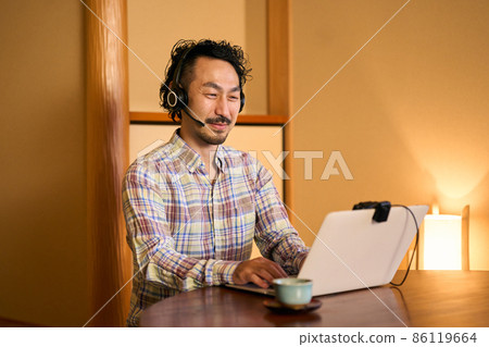 A bearded man who works remotely in a Japanese-style room 86119664