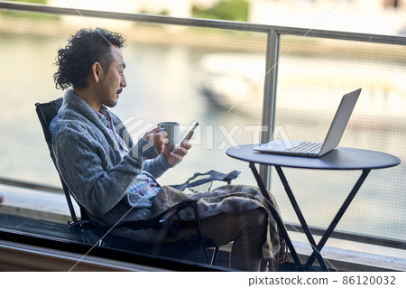 Bearded man working remotely on the balcony 86120032