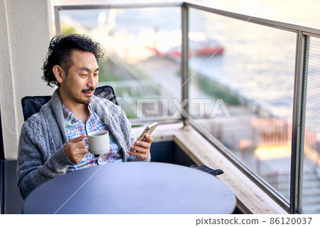 Bearded man working remotely on the balcony 86120037