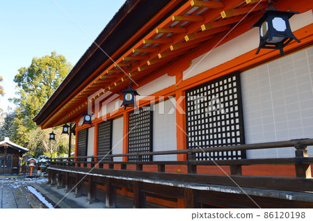 The west side of the national treasure main shrine of Yasaka Shrine in Higashiyama, Kyoto City, which was worshiped in January 2022 with snow, is beautiful. 86120198