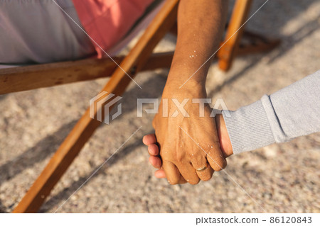 Cropped image of senior multiracial couple holding hands while enjoying retirement at beach Cropped image of senior multiracial couple holding hands while enjoying retirement at beach 86120843