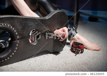 Female hands in wooden shackles during role-playing games. Shameful pillar and leather cuffs for sex. BDSM Domination and punishment. Female hands in wooden shackles during role-playing games. Shameful pillar and leather cuffs for sex. BDSM Domination and punishment. 86120845