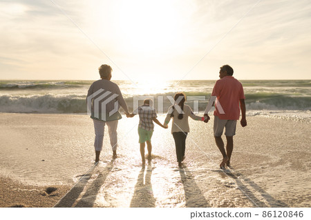Full length of multiracial grandparents and grandchildren holding hands walking together at beach Full length of multiracial grandparents and grandchildren holding hands walking together at beach 86120846