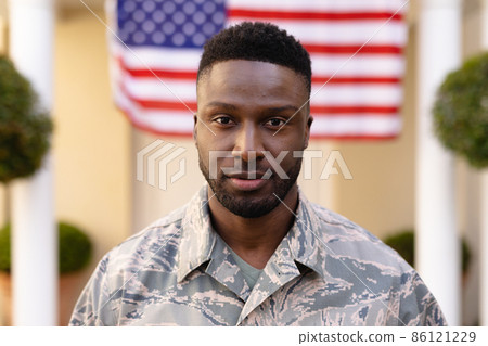 Portrait of confident male african american soldier wearing uniform against usa flag 86121229