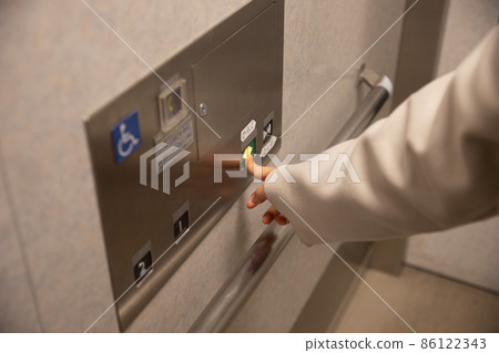 Female Elevator pushing a button in the elevator 86122343