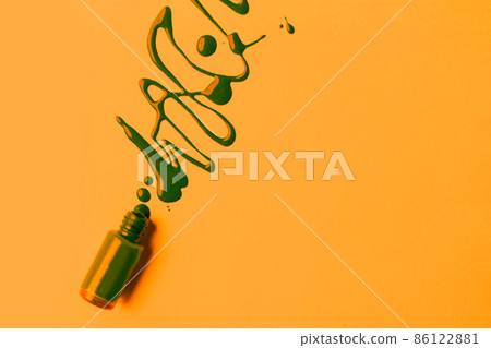 Blot of green nail polish and brush isolated on orange background with copy space for text. Manicure, pedicure, cosmetics concept. Blot of green nail polish and brush isolated on orange background with copy space for text. Manicure, pedicure, cosmetics concept. 86122881