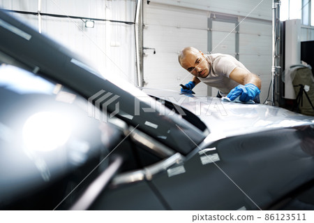 African American man car service worker applying nano coating on a car 86123511
