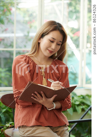 Woman Filling Gratitude Journal 86124326