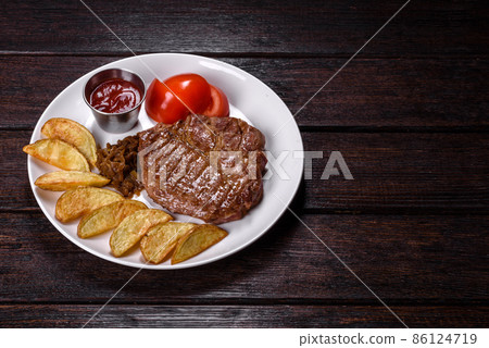 Delicious juicy beef steak with baked potatoes and sauces on a white dish 86124719