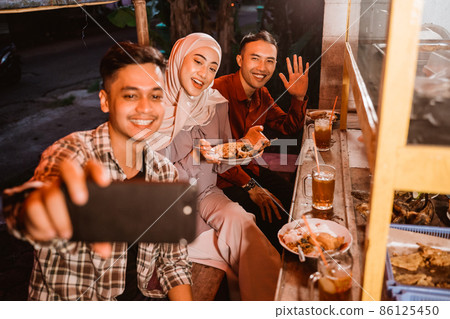 muslim friend take a selfie while dinner 86125450