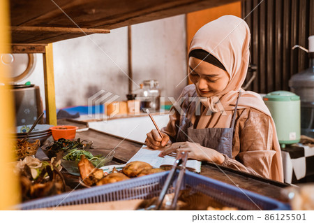 muslim food stall owner write note while working 86125501