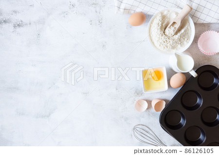 Ingredients and tools for cake preparation on grey background top view. 86126105