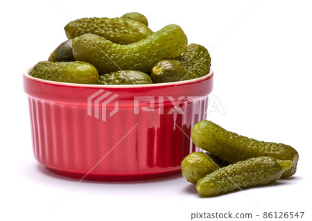 Plate of Tasty canned Whole green cornichons isolated on a white background 86126547