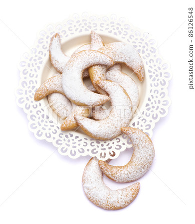 Traditional German or Austrian Vanillekipferl vanilla kipferl cookies on a plate isolated on white background 86126548