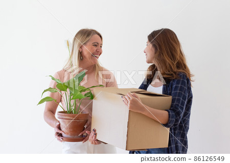 Thrilled mom and daughter moving things into new house 86126549