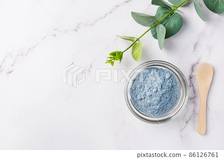 Dry facial blue clay powder in a bowl top view. Natural organic cosmetic clay for beauty treatment. 86126761