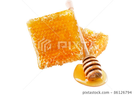 Sweet honey and honeycomb. Healthy organic honey, slices of honeycomb and wooden honey dipper isolated on white background. 86126794