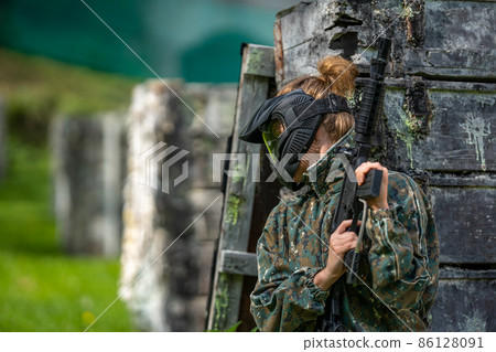 young woman in action while playing paintball 86128091