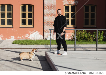 man is playing in the city with a dog man is playing in the city with a dog 86128468