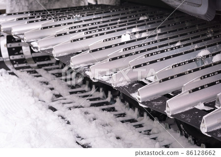 Metal tracks of a snowplow car in winter in the snow 86128662