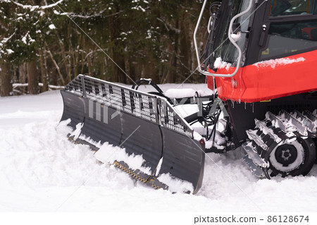 The bucket of a snowplow on tracks, standing in the forest in winter 86128674