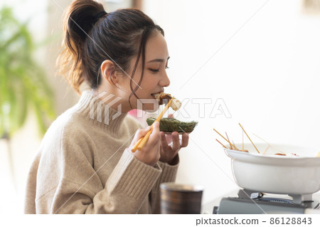 Cute woman eating oden 86128843
