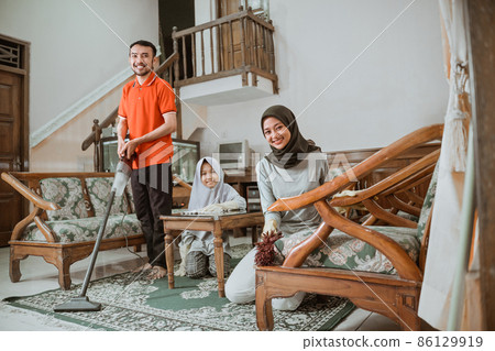 Asian mom and dad smiling while cleaning with vacuum Asian mom and dad smiling while cleaning with vacuum 86129919