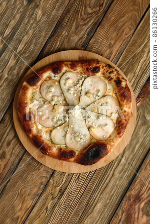 Pizza with pears and Gorgonzola cheese, italian pizza with pear and blue cheese on a wooden background Pizza with pears and Gorgonzola cheese, italian pizza with pear and blue cheese on a wooden background 86130266