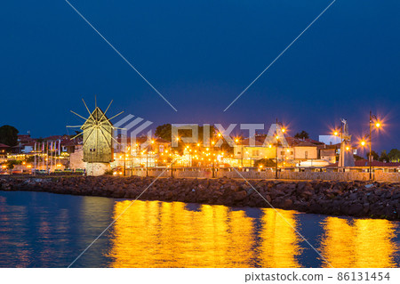 Bulgarian world heritage ancient city, illuminated windmill standing in front of the old town of Nessebar Bulgarian world heritage ancient city, illuminated windmill standing in front of the old town of Nessebar 86131454
