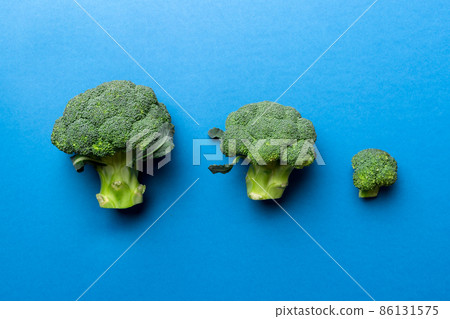 green fresh broccoli background close up on colored table. Vegetables for diet and healthy eating. Organic food green fresh broccoli background close up on colored table. Vegetables for diet and healthy eating. Organic food 86131575