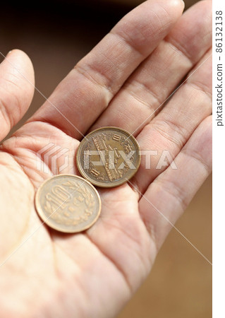 手拿著舊的十日元硬幣左手拿著二十日元硬幣 86132138