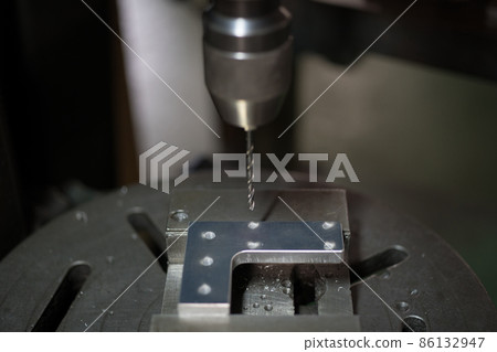 用鑽孔機在零件上鑽孔 用鑽孔機在零件上鑽孔 86132947