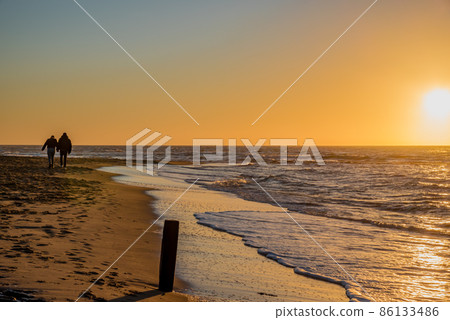 Den Helder, Netherlands. January 2022. Setting sun on the beach of Den Helder, Netherlands. 86133486