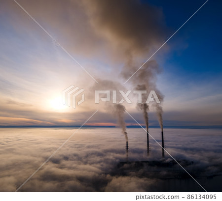 Aerial view of coal power plant high pipes with black smoke moving up polluting atmosphere at sunset 86134095