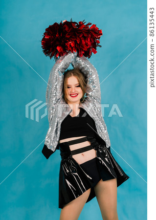 Young lady cheerleader posing in the studio, isolated on red and blue 86135443