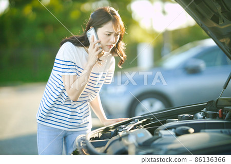 Young woman calling due to car breakdown Young woman calling due to car breakdown 86136366