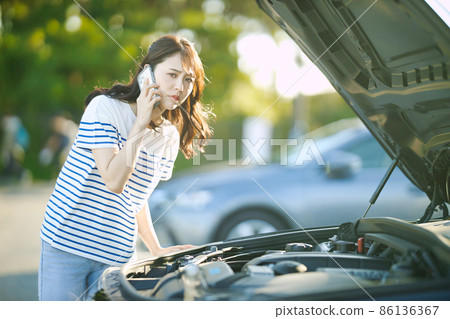 Young woman calling due to car breakdown Young woman calling due to car breakdown 86136367