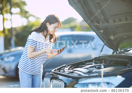 Young woman calling due to car breakdown Young woman calling due to car breakdown 86136370