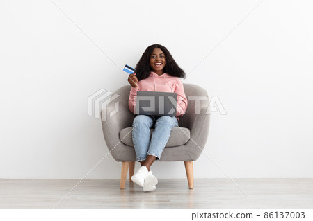 Relaxed black lady making online order, using computer Relaxed black lady making online order, using computer 86137003