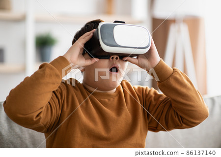 Amazed chubby boy with VR glasses, home interior 86137140