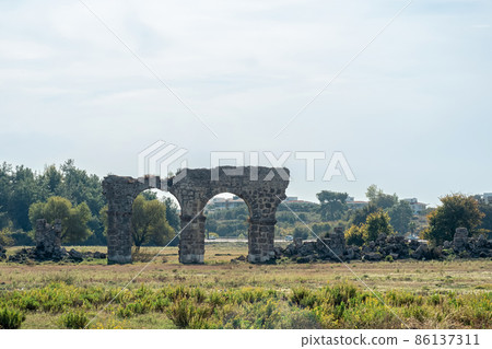 ruin of an ancient Roman aqueduct in a city wasteland near the ancient city of Side in Turkey 86137311