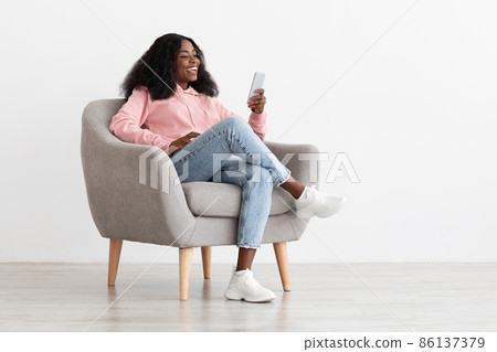 Positive pretty black lady having video call on smartphone 86137379