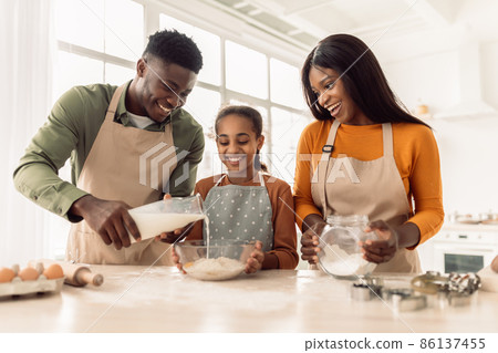 African Family Baking Pastry Adding Milk To Dough In Kitchen African Family Baking Pastry Adding Milk To Dough In Kitchen 86137455