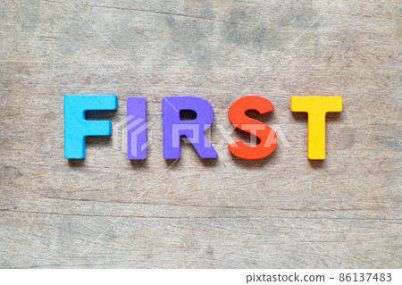 Color alphabet letter with word first on wood background 86137483