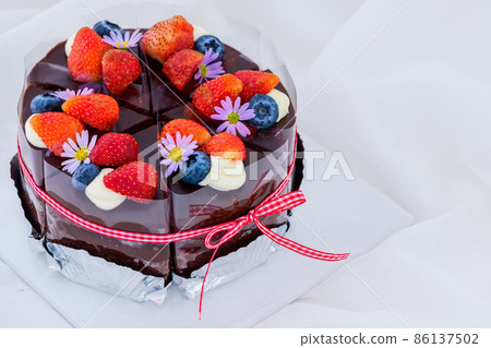 chocolate cake decorated with fresh strawberry and blueberries on top, 86137502