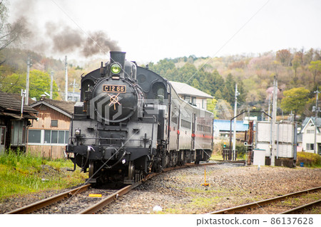 Three SL trains of passenger cars pulled by a C12 steam locomotive that shelves smoke from the chimney and waits for departure in the balmy afternoon of spring. Three SL trains of passenger cars pulled by a C12 steam locomotive that shelves smoke from the chimney and waits for departure in the balmy afternoon of spring. 86137628