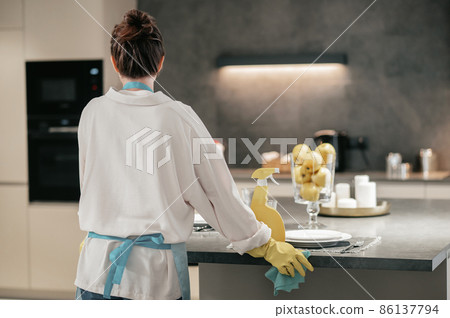 A woman looking busy while cleaning the kitchen 86137794