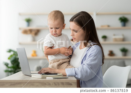 Working Mom. Woman Using Laptop At Home And Taking Care About Baby 86137819