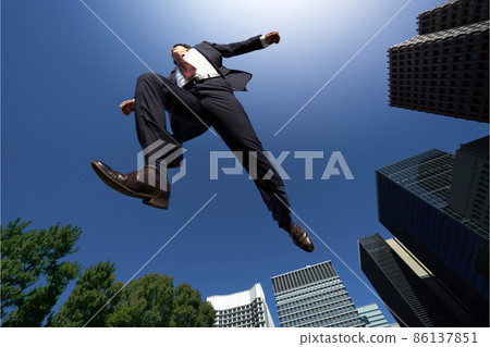 A man in a suit running in the blue sky 86137851