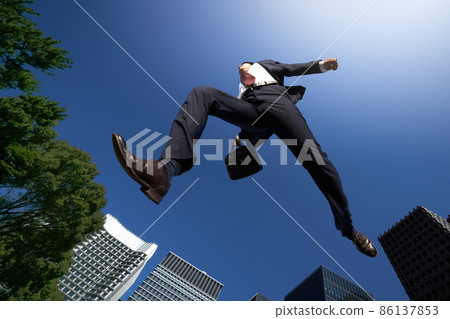 一個穿著西裝的商務人士在藍天中奔跑 一個穿著西裝的商務人士在藍天中奔跑 86137853